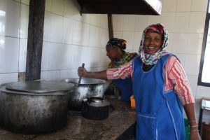 La Buzunesh, cocinera, y la Adisu ayudante de cocina con las ollas de la comida.